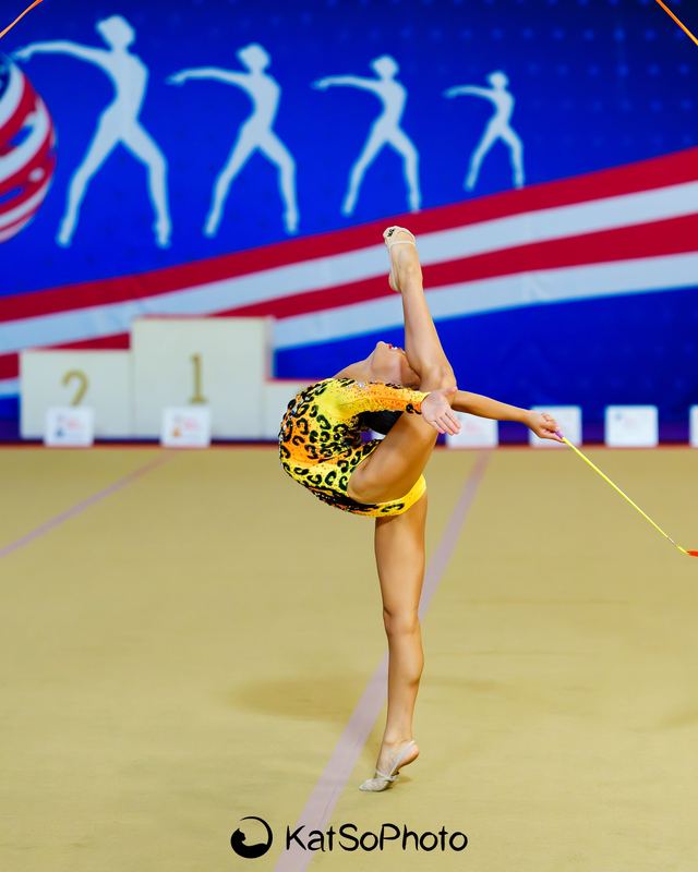 A gymnast arched over a hoop mid-routine at a national meet
